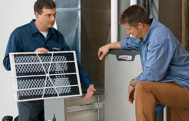 technician showing customer how to change air handler filter